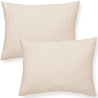 Two beige Makemake Organics throw pillows with a subtle white polka dot pattern, displayed on a white background.