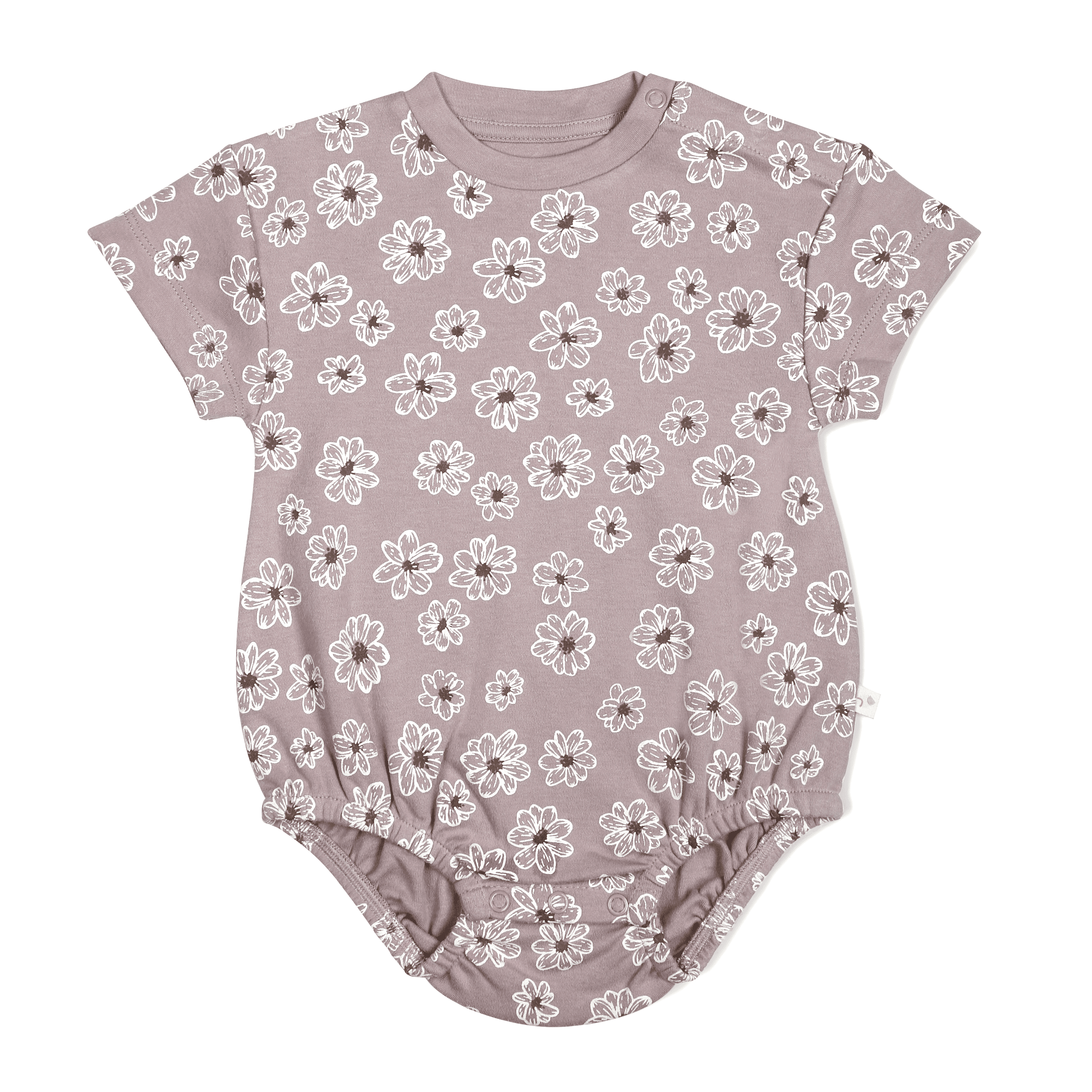 A toddler's short-sleeved bodysuit in a soft pink color, featuring an all-over white floral print, displayed flat on a white background. Organic Bubble Romper - Daisies by Makemake Organics.