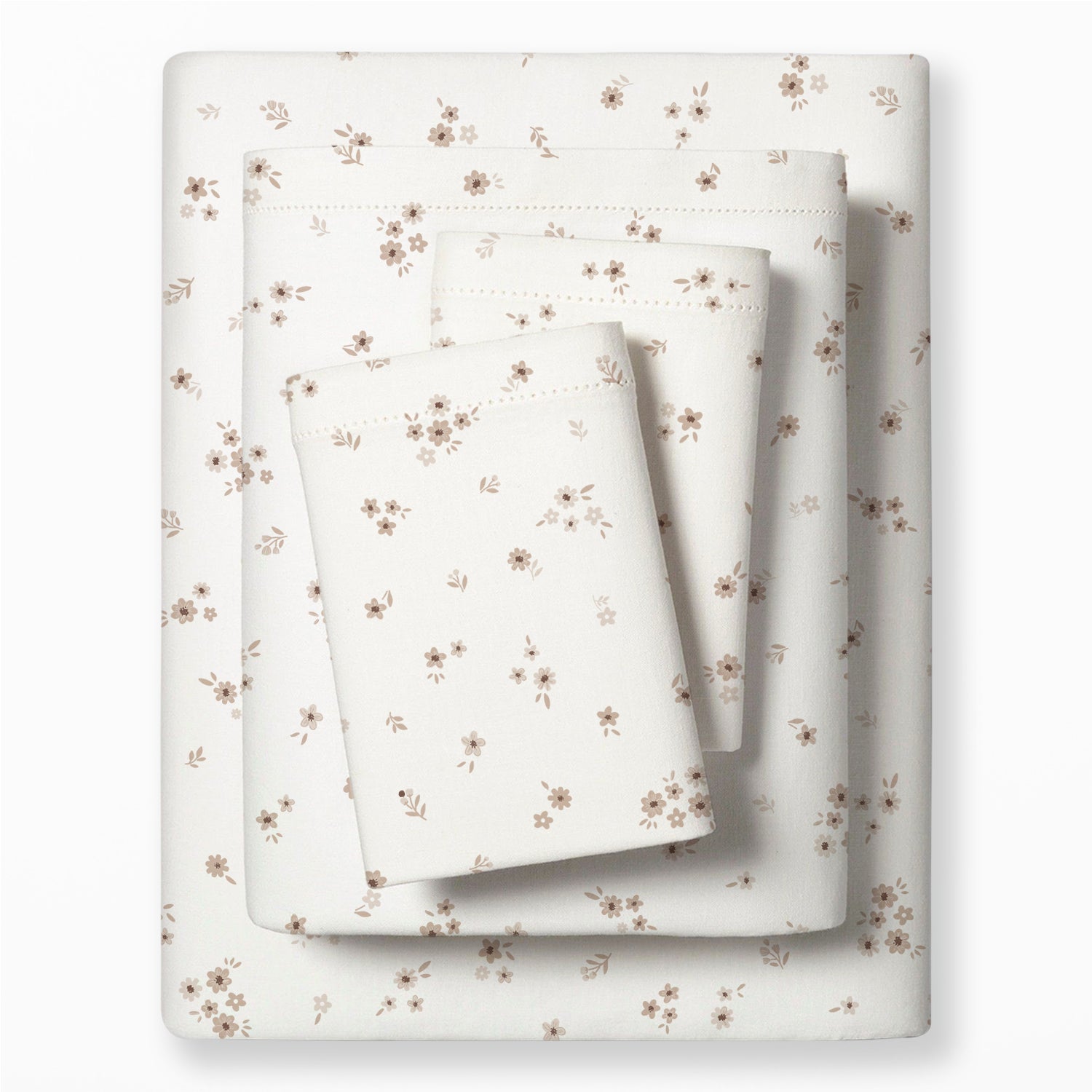 A neatly folded set of cream-colored bedding with a delicate brown floral pattern, consisting of a fitted sheet, flat sheet, and pillowcases from Makemake Organics' Organic Cotton Sheet Set - Bloom, displayed on a white background.