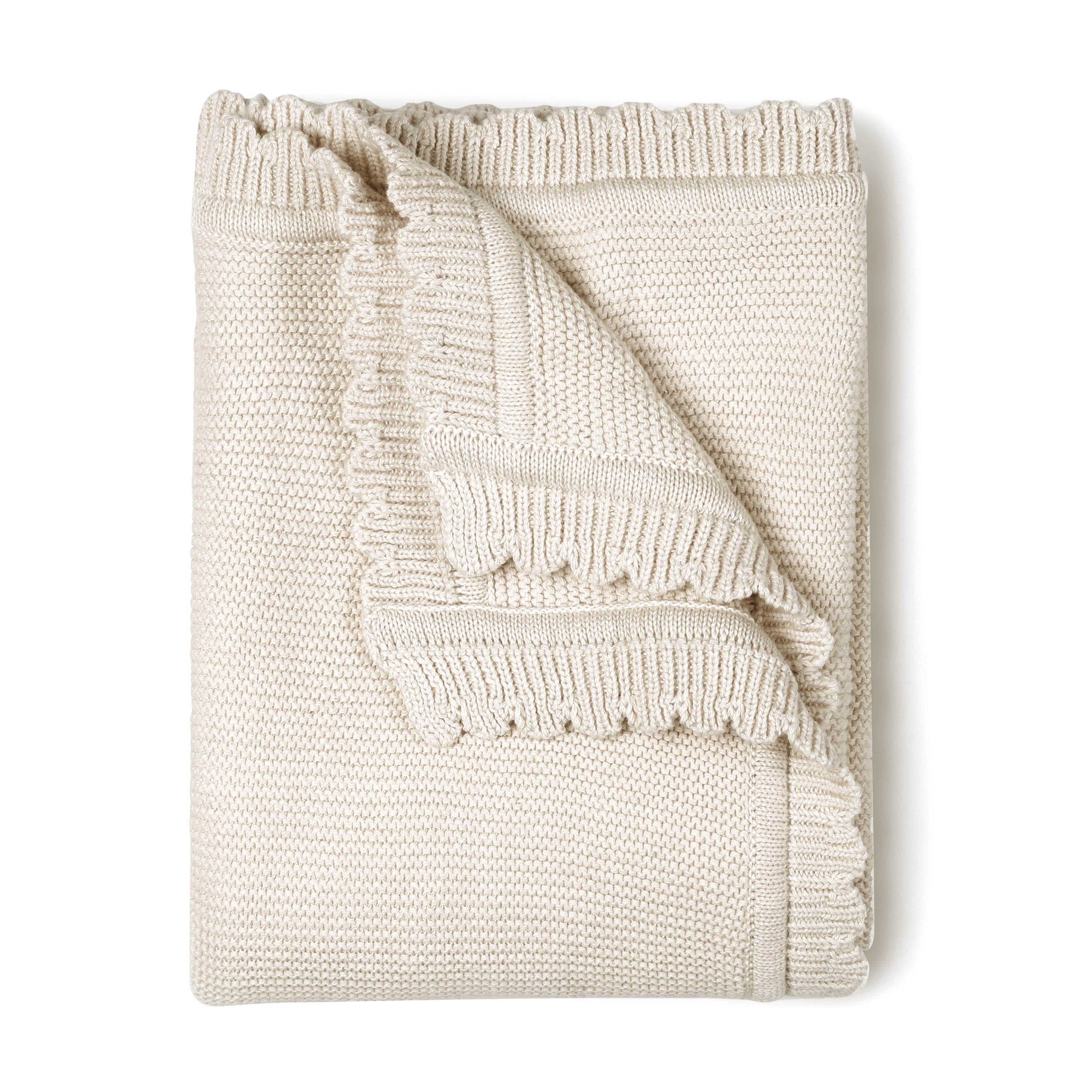 A neatly folded Organic Cotton Scalloped Baby Blanket in Vanilla Natural from Makemake Organics with a textured pattern, partially unfolded at one corner to reveal its design.