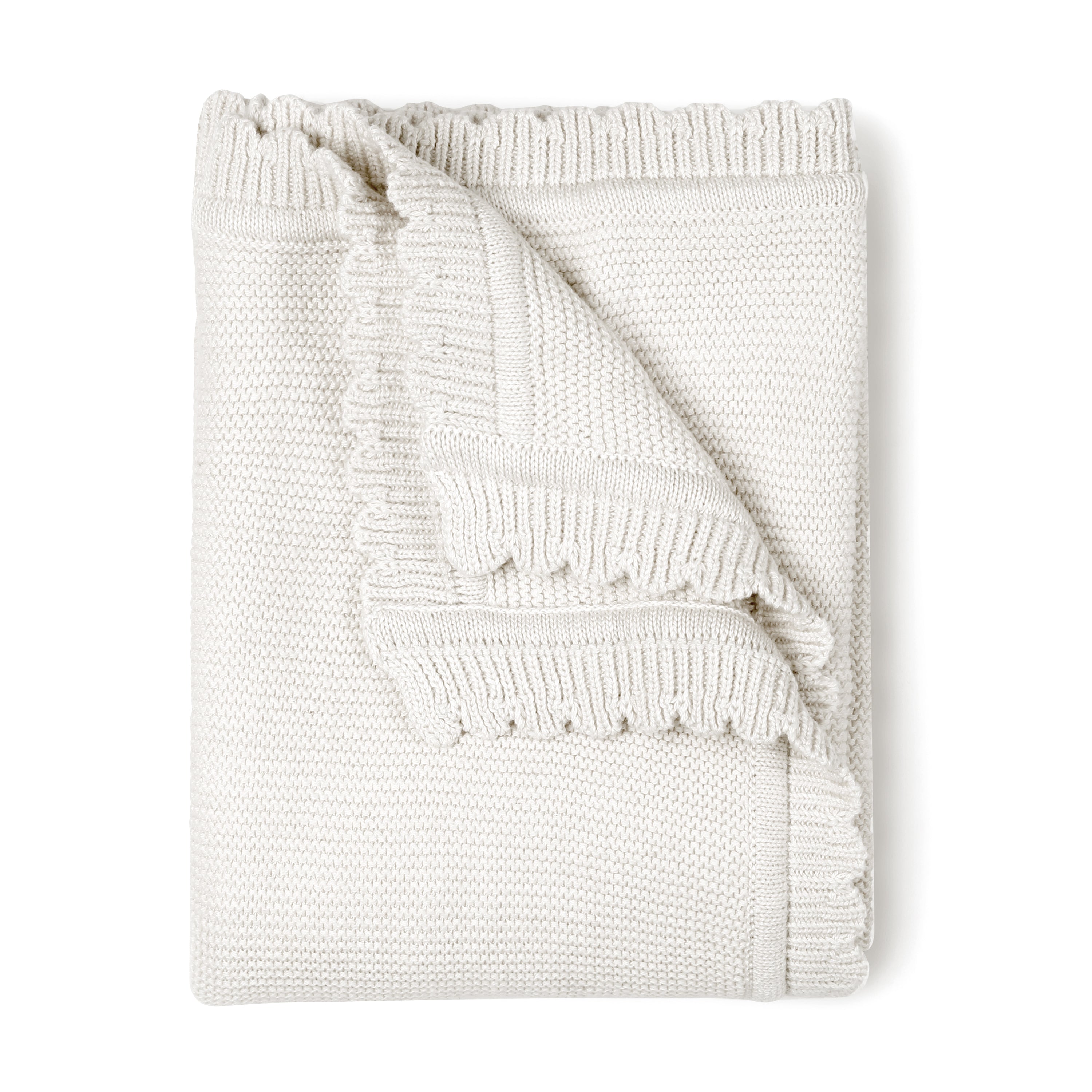 A neatly folded Ella Ivory Organic Cotton Scalloped Baby Blanket with a textured pattern, partially unfolded at one corner, isolated on a white background.
