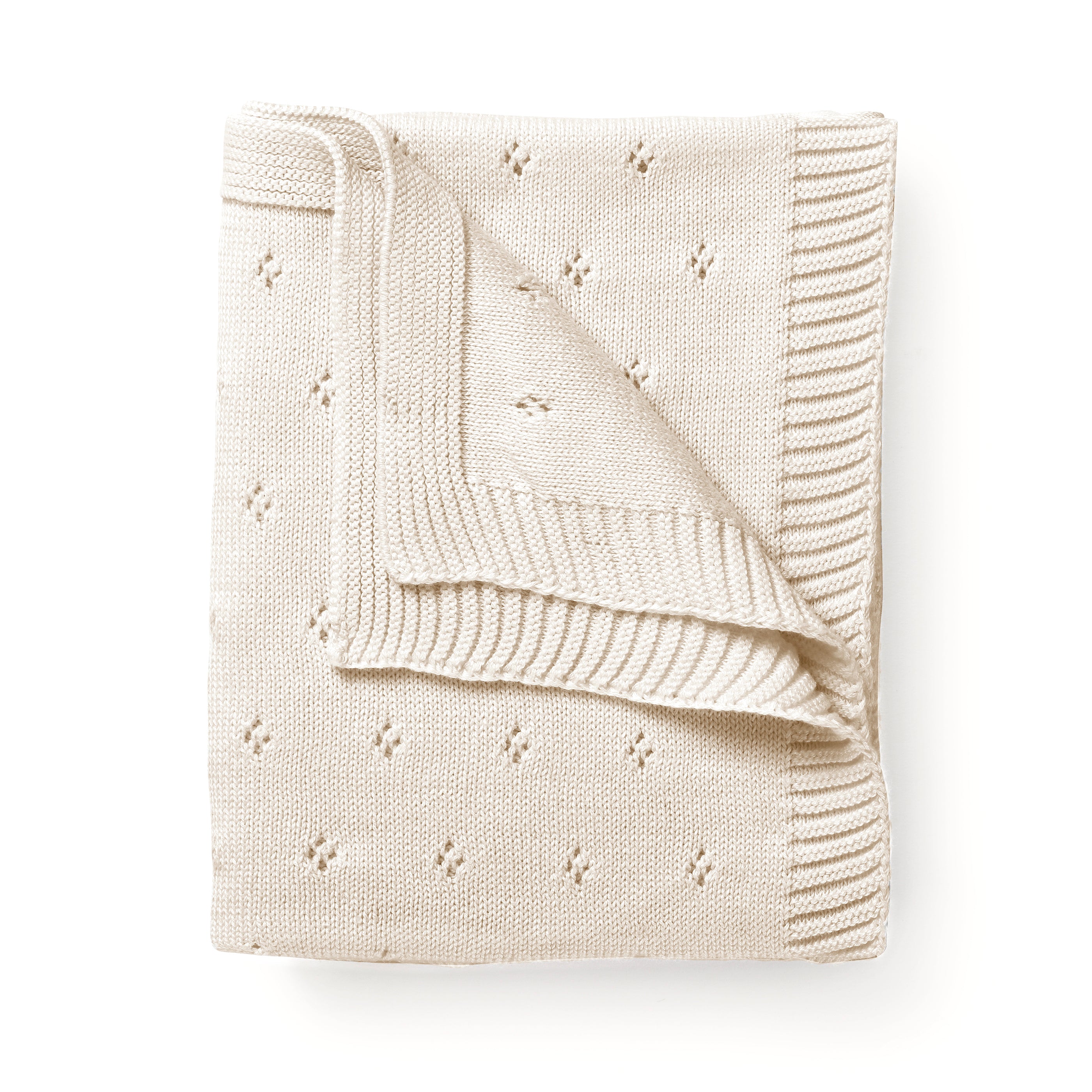 A Organic Cotton Pointelle Baby Blanket in Vanilla Natural from Makemake Organics, with a textured border and small, evenly spaced embroidered flowers, neatly folded on a white background.