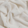 Close-up of an Ella Ivory Organic Cotton Pointelle Baby Blanket by Makemake Organics with intentional small holes and textured patterns, highlighting its softness and intricate weaving.