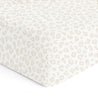 A close-up of a Crib Fitted Sheet with Pillowcase - Wild from Makemake Organics, featuring a subtle, beige, leopard-print pattern on a white background.