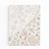 A Crib Fitted Sheet with Pillowcase - Blossom from Makemake Organics, partially flipped open to reveal a ruffled edge. the notebook is positioned against a white background.