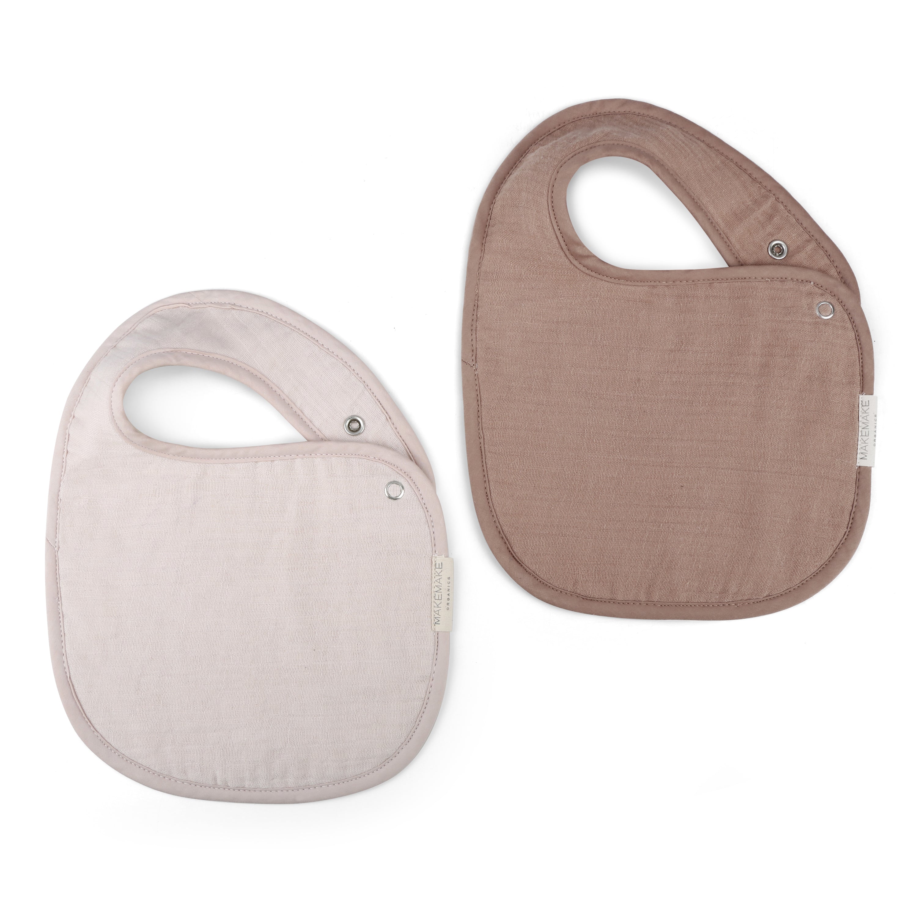 Two Organic Muslin Bibs - Blush Oat & Pecan by Makemake Organics, one pink and one brown, displayed side by side on a white background, each with snap closures visible.
