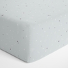 A Milky Way fitted crib sheet decorated with a subtle white and purple star pattern, neatly arranged on a mattress with smooth, tightly pulled corners. Brand Name: Makemake Organics