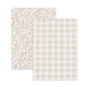 Two Mini Crib Fitted Sheet Sets: one with a Blossom floral design in pink and beige tones, and the other with a Plaid beige and white gingham pattern by Makemake Organics.