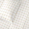 Two pillows with beige and white checkered pillowcases on a Makemake Organics Organic Cotton Sheet Set - Plaid, arranged diagonally on a plain light background.