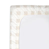 A white Organic Cotton Changing Pad Cover - Plaid with a patterned border featuring a geometric design in light beige and white shades, isolated on a white background, by Makemake Organics.