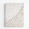 A soft, folded Organic Cotton Sheet Set - Blossom with a floral pattern in pastel shades of pink, green, and white, elegantly displayed against a white background by Makemake Organics.