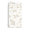 A baby's crib mattress covered with a Makemake Organics Organic Cotton Changing Pad Cover - Safari that features a jungle-themed print including zebras, elephants, giraffes, and tropical foliage in soft beige tones.