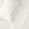 Close-up view of a Makemake Organics Organic Cotton Sheet Set - Wild featuring a subtle, light beige animal print pattern on a soft, textured fabric.