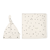 Two cream-colored cosmetic bags with black polka dots; one bag is a pouch with a knotted tie and the other is a flat square shape with a zipper, both featuring a "Makemake Organics" logo.