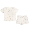 A cream-colored children's outfit featuring a short-sleeved organic tee and shorts set in the Pixie Dots pattern, both adorned with a black polka dot pattern, isolated on a white background by Makemake Organics.
