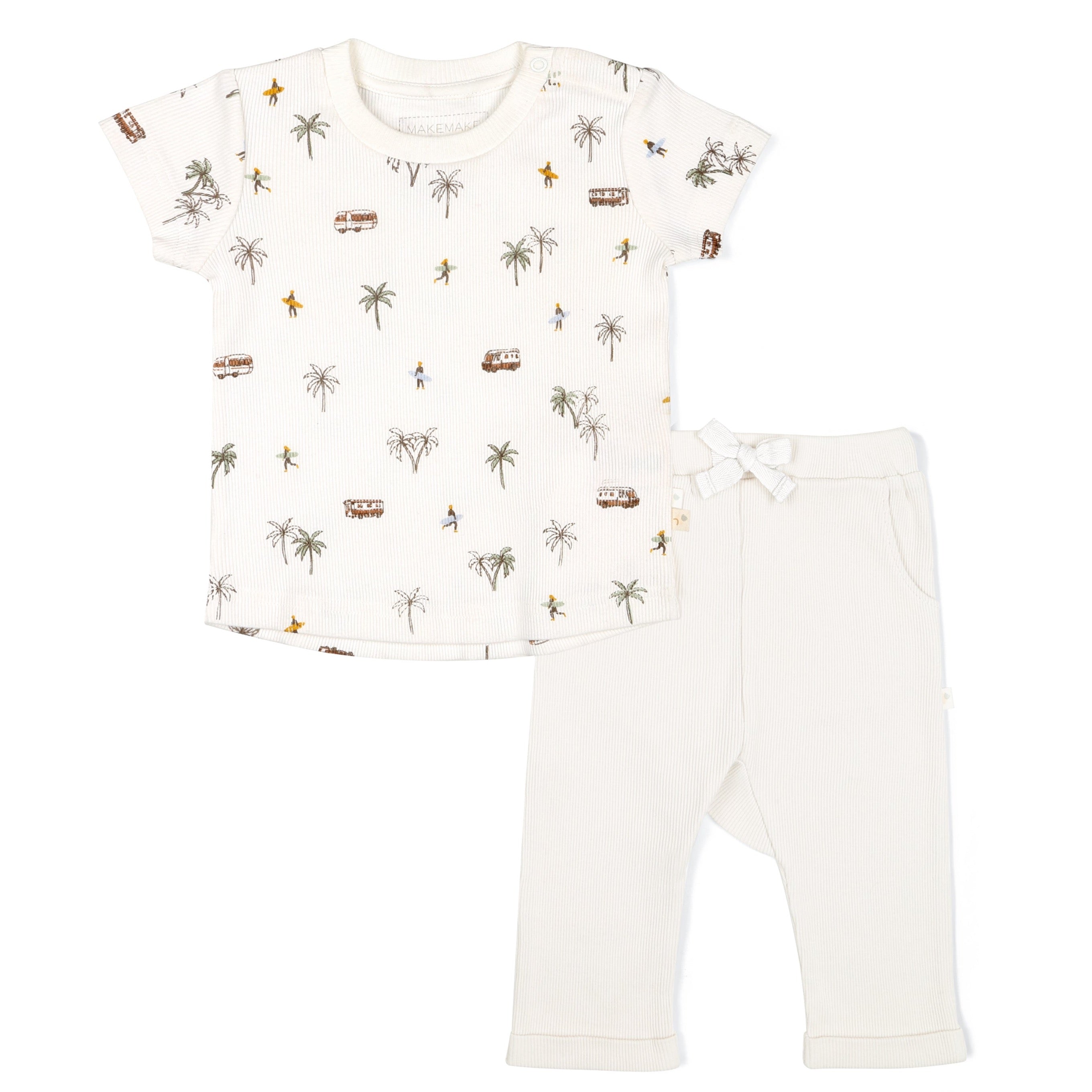 A white baby outfit consisting of a Organic Tee & Pants Set - Malibu from Makemake Organics featuring palm trees and beach images on the shirt, and plain white pants with a bow on one side.