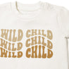 Close-up of a white baby Organic Tee & Pants Set - Wild Child from Organic Kids with the phrase "wild child" printed in bold, beige letters repeated thrice on the chest area, featuring snap buttons on the inseam.