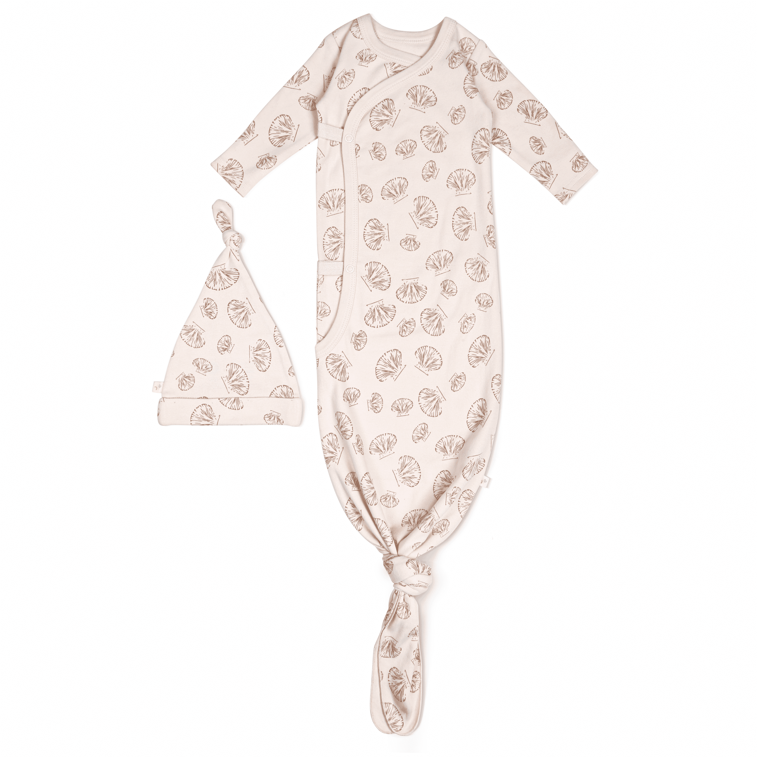 A beige newborn baby Organic Kimono Knotted Sleep Gown in Seashells and matching hat with a leaf pattern, displayed on a white background by Makemake Organics.