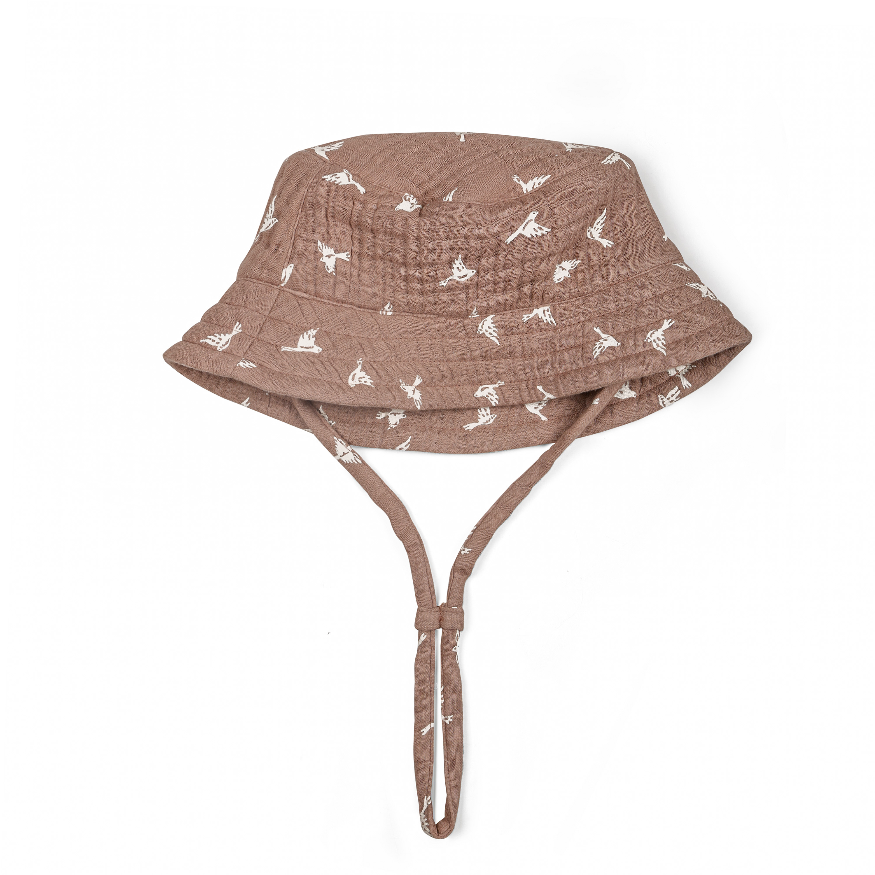 A brown Organic Muslin Bucket Sun Hat for a baby boy with a playful white bird print and a securing chin strap, isolated on a white background by Makemake Organics.