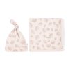 A pale pink Organic Swaddle Blanket & Hat - Seashells with a leafy pattern, both displaying the brand "Makemake Organics" on them, are laid out flat on a white background.