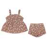 A toddler girl's Organic Muslin Peplum Top and Shorts Set in Flock by Makemake Organics laid flat on a white background, consisting of brown shorts and a matching brown ruffled top with white sailboat print.