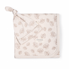 A square, beige Organic Swaddle Blanket & Hat - Seashells with a leaf pattern, featuring a knotted corner and a button closure, labeled "Makemake Organics". the blanket is displayed on a plain background.