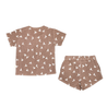 A brown toddler girl's Makemake Organics Organic Muslin Top and Shorts 2 Piece Set - Flock, displayed on a white background.