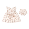 A toddler girl's outfit consisting of an Organic Flutter Dress - Seashells and matching bloomers, both featuring a leaf pattern on a light beige background, displayed against a white surface by Makemake Organics.