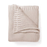 Chunky Knit Throw Blanket - Nora Shell by Makemake Organics neatly folded over itself, isolated on a white background, showcasing its textured weave and cozy appearance.