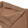 Close-up of a brown Organic Baby fabric with a folded collar featuring multiple silver snap buttons.