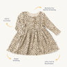A Organic Baby gots-certified, long-sleeve baby dress with a leopard print, highlighted features like stretchiness, softness, breathability, and buttons for easy dressing.