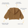 A flat-laid, oversized tan Organic Hooded Jacket from Organic Baby, featuring a large hood and elastic cuffs, with labels indicating it is made from 100% GOTS certified cotton and offers room