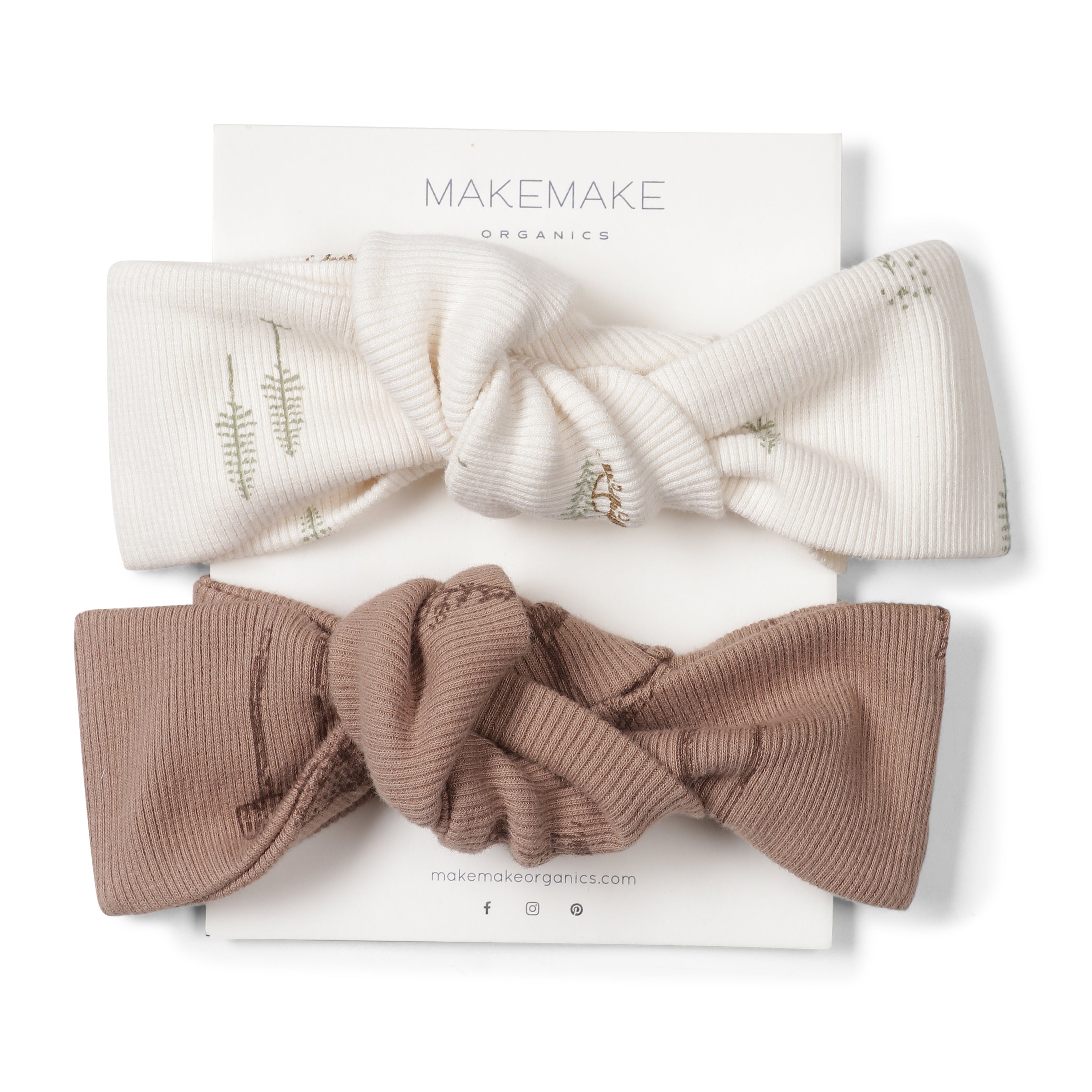 Two Organic Headwraps in Wildwood and Evergreen Fir colors, decorated with subtle embroidery, displayed atop a Makemake Organics branded card on a white background.