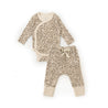 A baby's outfit from Organic Baby with a leopard print design consisting of a long-sleeve kimono-style top and matching pants with a bow tie at the waist, displayed on a.