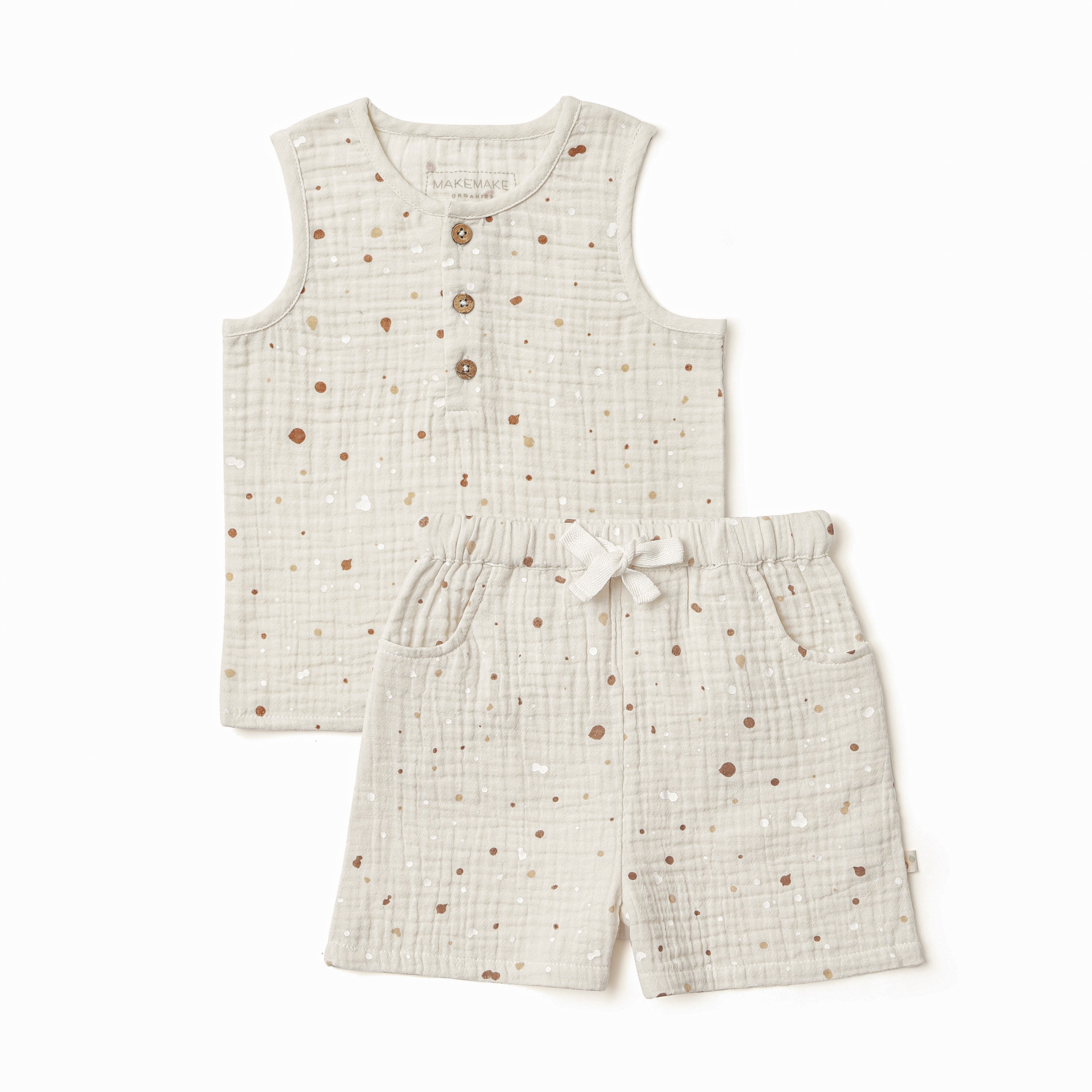 Two-piece children's outfit from Organic Kids displayed on a white background, consisting of a beige sleeveless top with brown button detail and matching shorts with a drawstring waist, both featuring a speckle print.