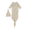 A beige Organic Baby Kimono Knotted Sleep Gown in Camplife, with a knotted design and a matching hat, both adorned with a subtle print of animals and trees, displayed on a white background.