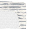 A close-up of a Makemake Organics mattress corner with an Organic Cotton Cobi Blue Stripes fitted sheet featuring a white background and horizontal navy blue stripes. The mattress has a quilted pattern visible on its side.